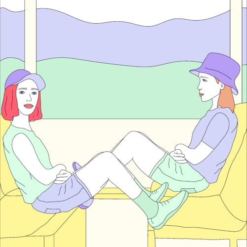 Friends sitting opposite each other on a train travelling through the countryside
