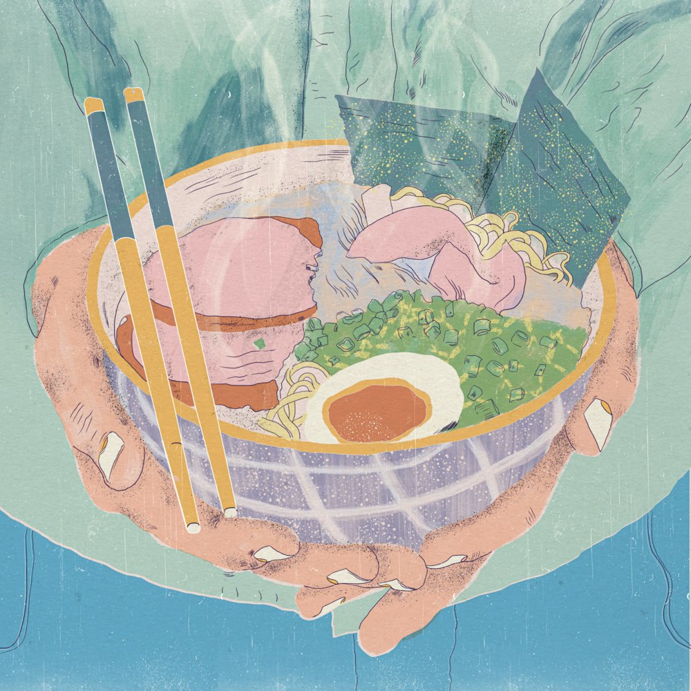 Hands holding a bowl of ramen