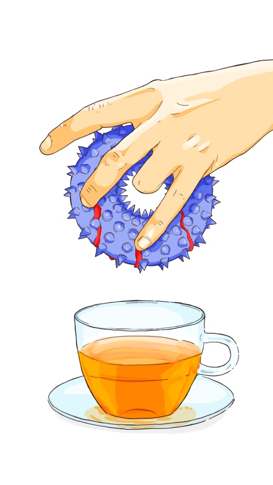 Person dunking a donut into a cup of tea