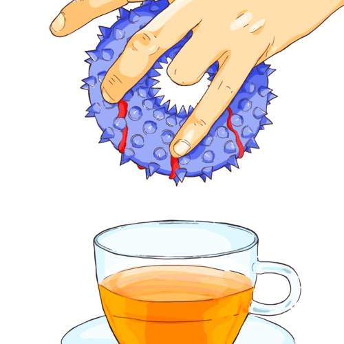 Person dunking a donut into a cup of tea