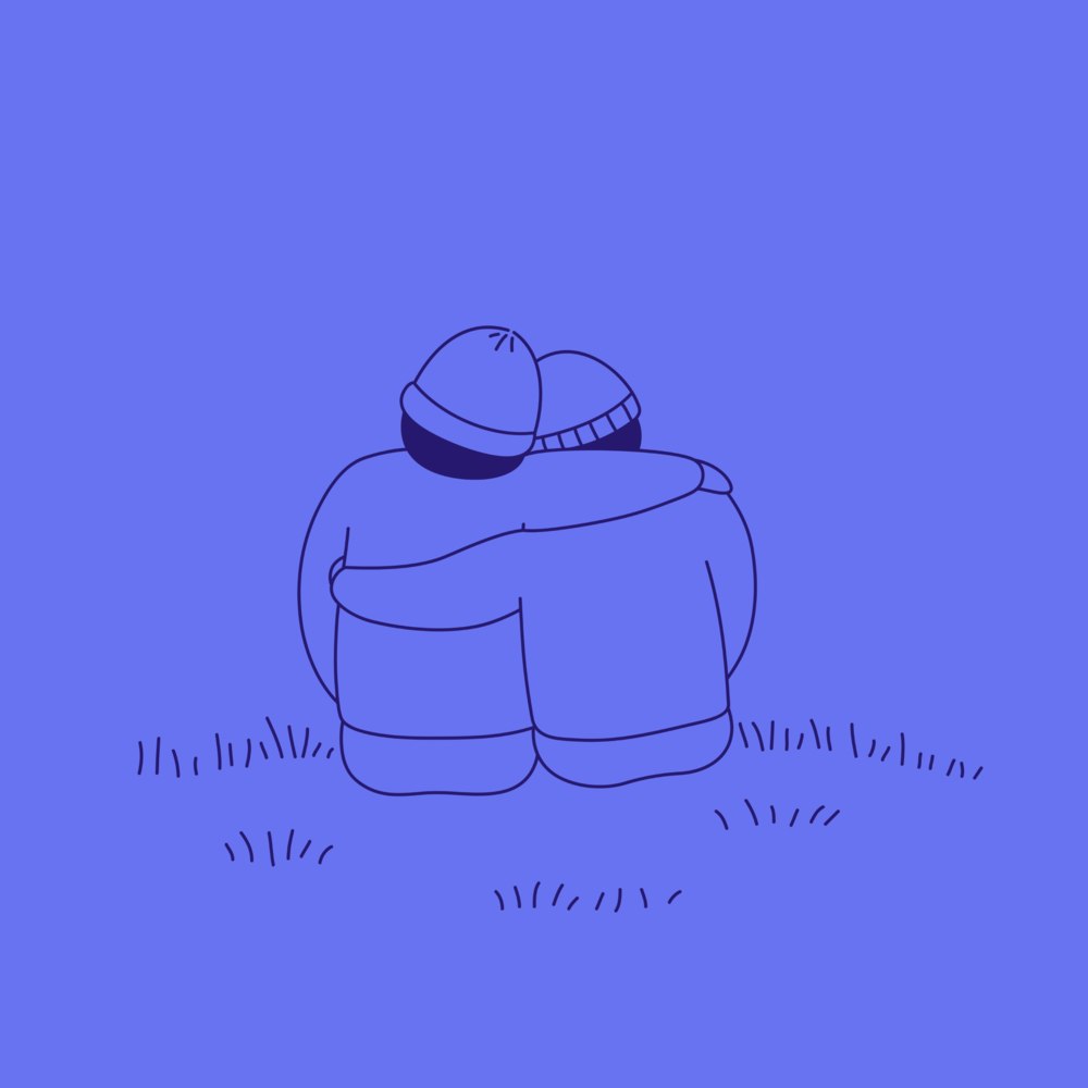Two people sitting on the grass, arm in arm