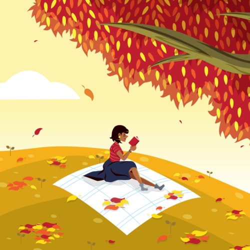 Woman reading a book next to an autumnal tree with falling leaves