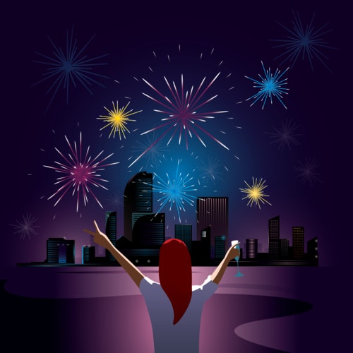 Woman watching fireworks over a city skyline