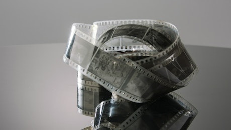 35 mm film and its reflection on a mirror surface.