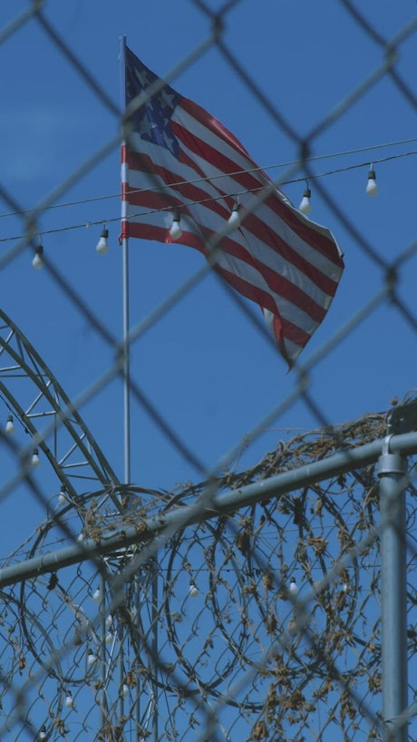 9-star USA flag waving behind a mesh.