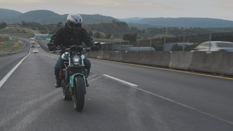 A biker speeding up on a highway
