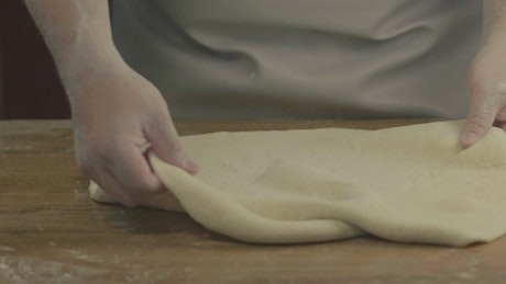 A chef preparing pizza dough.