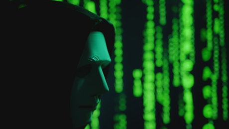 A computer hacker with a mask in black hood.
