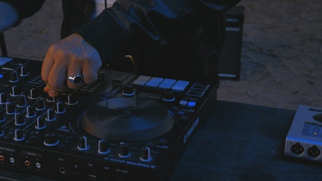 A DJ spinning tracks during sunset in the desert.