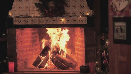 A fireplace lit at Christmas time.