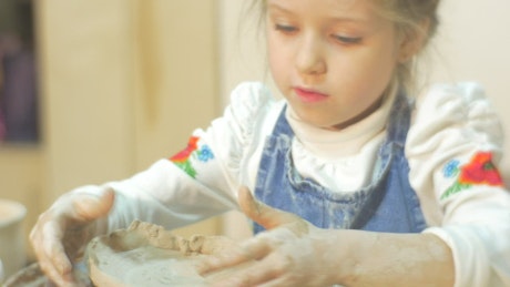 A Girl molding clay.