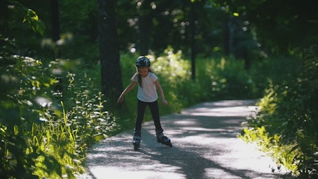 A girl with a helmet skating in the park.