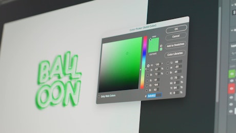 A graphic designer working with a color picker for a typography that says ballons..