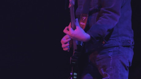 A guitarist playing a song on stage