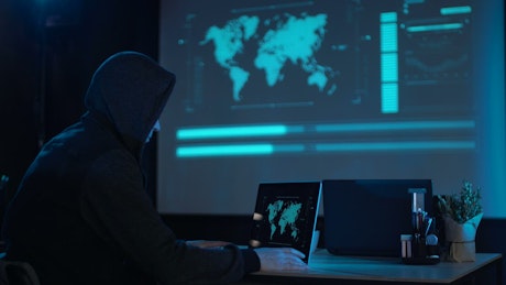 A hacker with the laptop in a dark room.