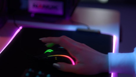 A hand moving a RGB gaming mouse in a gaming session.
