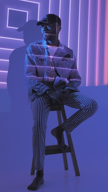 A hipster sitting on a chair under lights
