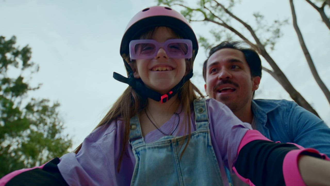 Seorang gadis kecil belajar mengendarai sepeda dengan bantuan ayahnya 888slot