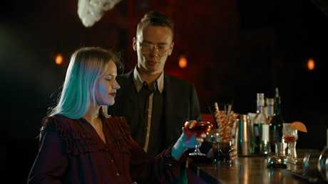 A man and a woman chatting at a bar counter