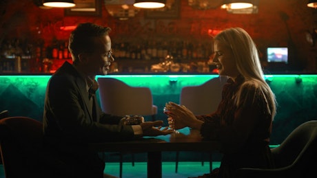 A man and a woman during a romantic date in a bar.