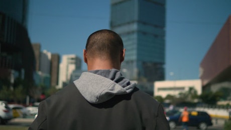 A man being followed walking in a city