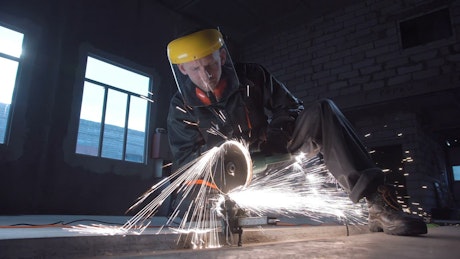 A man cutting metal with machine.