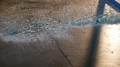 A man sweeping shattered glass.