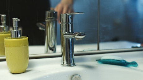 A man washing his hands in the bedroom.