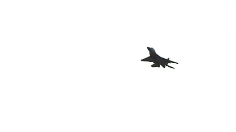 A military jet plane flying.