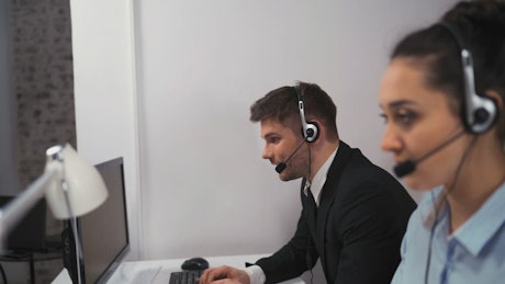 A pair of employees working in a call center.