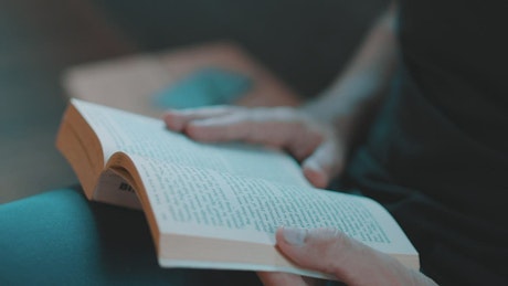 A person reading a book, close up.