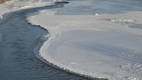 A river flowing between frozen water