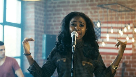 A singer performing with a band indoors