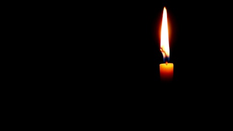 A single candle burning in the dark
