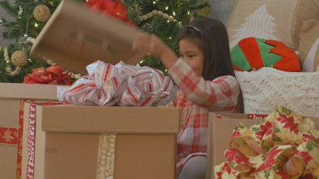 A very excited girl opening her Christmas presents.