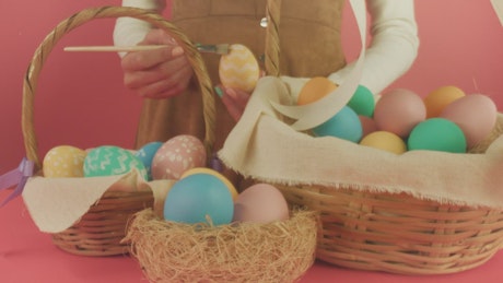 A woman decorates Easter eggs