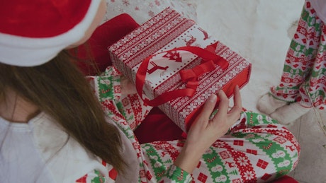 A woman opening a Christmas present.