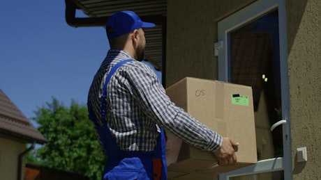 A woman receives a package from the delivery guy