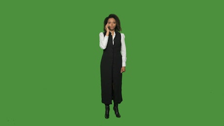 A woman talking on the phone on a green screen