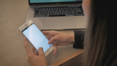 A woman writing an email on her smartphone.