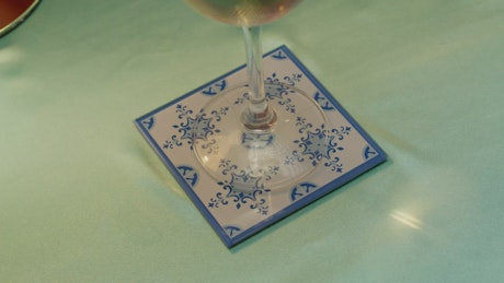 A woman's hand stirring a glass with white wine.