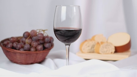 A woman's hand takes a glass of wine from an elegant image composition.