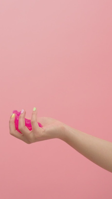 A woman's hands manipulating pink slime.