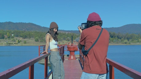 A young couple filming a video by the lake.