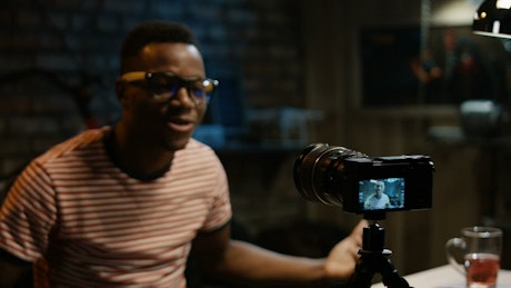 A young man recording himself with a camera.