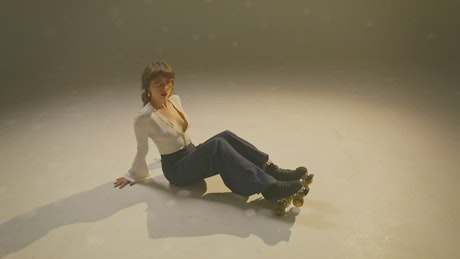 一个年轻女子在地上挥舞着旱冰
