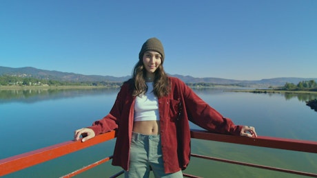 A young woman in knit hat by the lake.