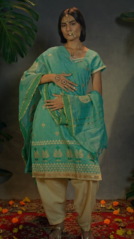 A young woman with traditional Indian jewelry and attire posing.