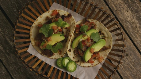 Above view of two tacos with avocado.