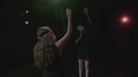 Abstract performance of two women with masks
